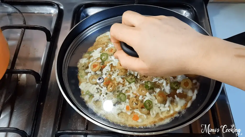 My hand on a lid of a cooking pan while making my favourite omelette.